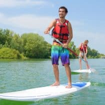 Camping de la Liez couple paddle boarding on lake