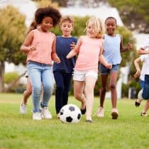 Camping de la Liez Group Of Children Playing Football With Friends In Park